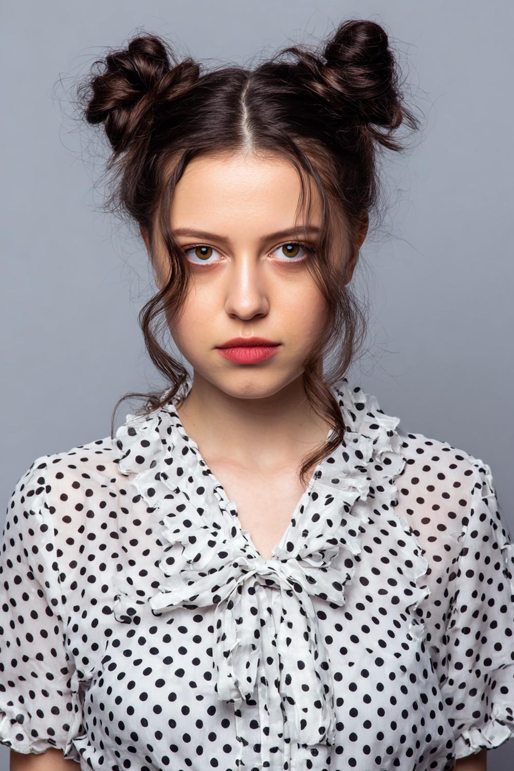 24. Space Buns Hairstyle with Symmetry and Wispy Front Tendrils