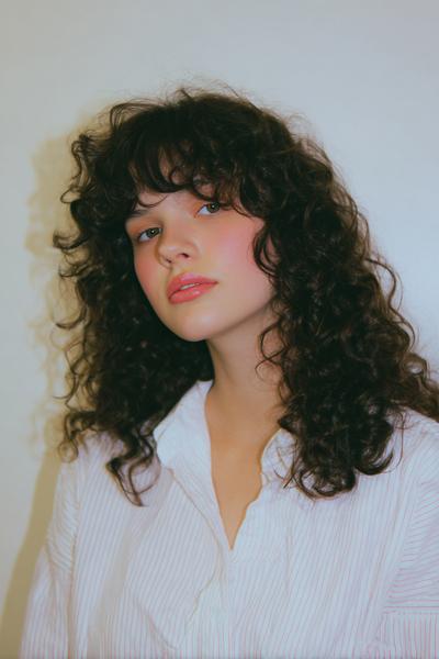 22. Curly Curtain Bangs Look for Hairstyles for School Curly Hair Down with Airy Face Framing