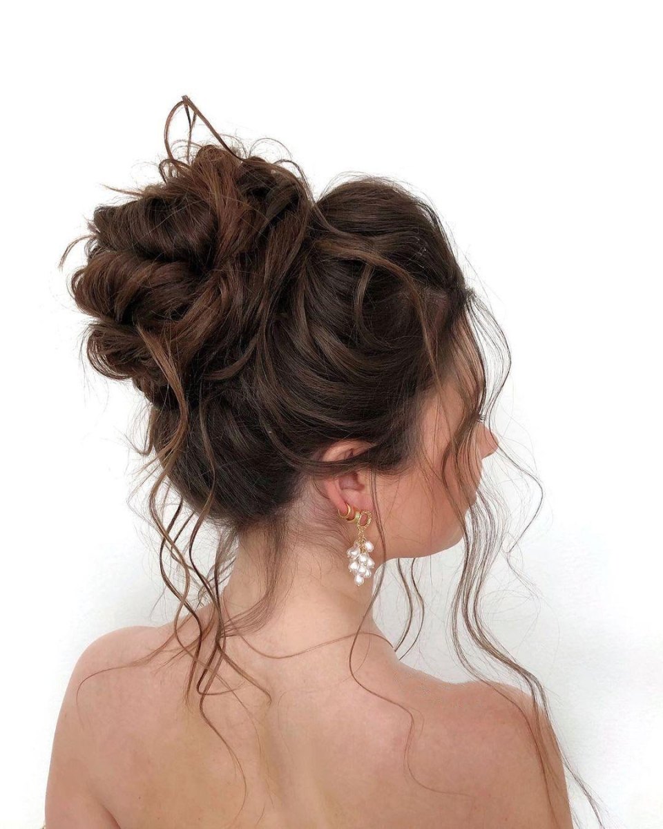 Brunette messy high bun updo with soft twists