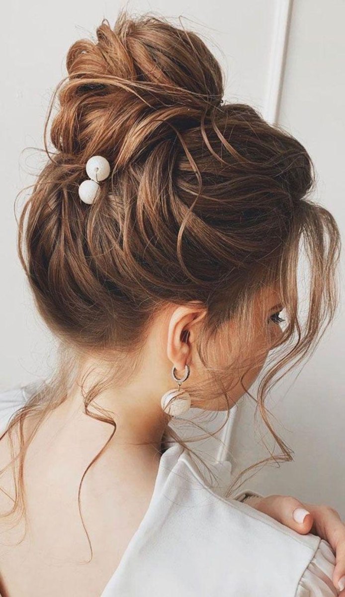 Blonde messy high bun updo with airy volume