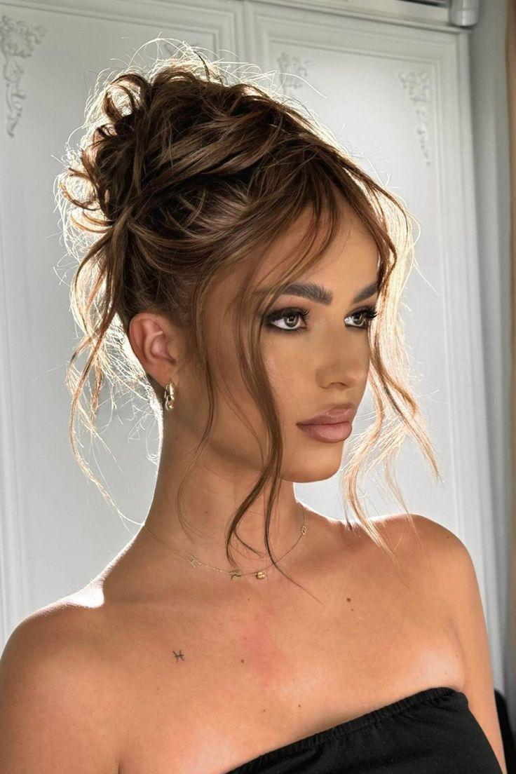 Warm highlighted messy high bun updo design