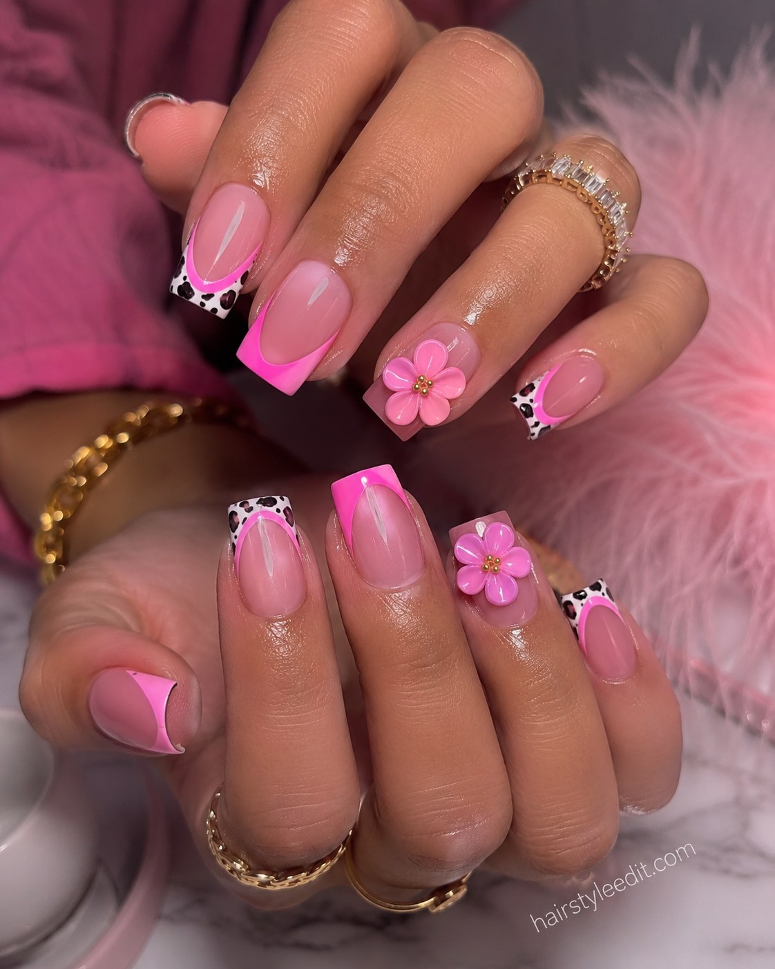 Short pink nails with electric pink French tips, cow print accent and 3D flower charm